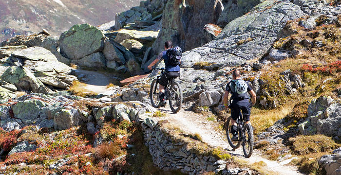 Zwei Bikers unterwegs auf einem Singletrail in den Bündner Bergen