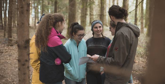 Junge Menschen stehen zusammen im Wald