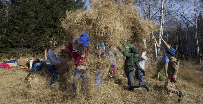 Kinder werfen Heu in die Luft