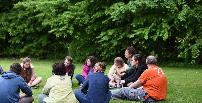 Junge Menschen sitzen im Gras