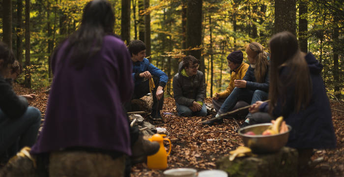 Groupe de jeuns assis dans la forêt