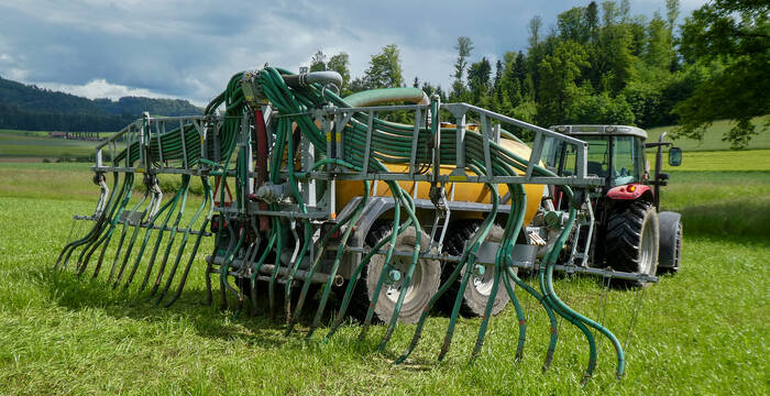 Traktor mit Schleppschlauch und Fass auf dem Feld. © Andrea Haslinger