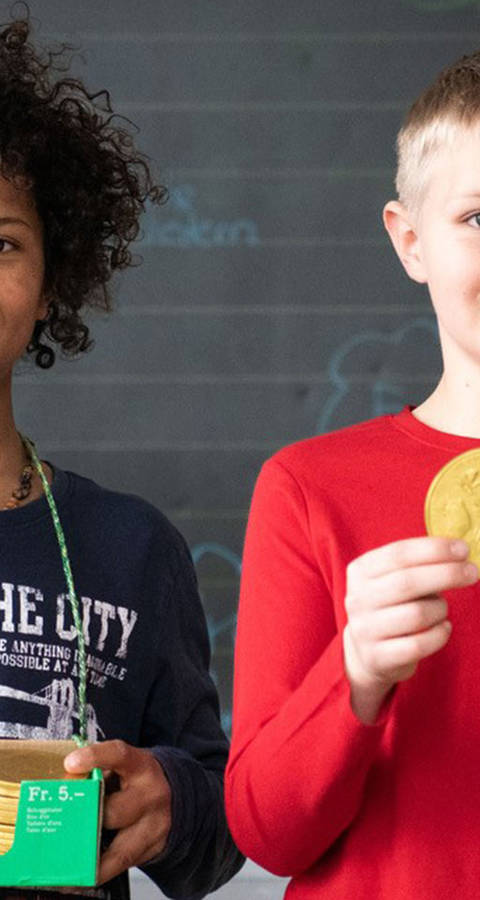 Schulkinder halten den Schoggitaler in den Händen