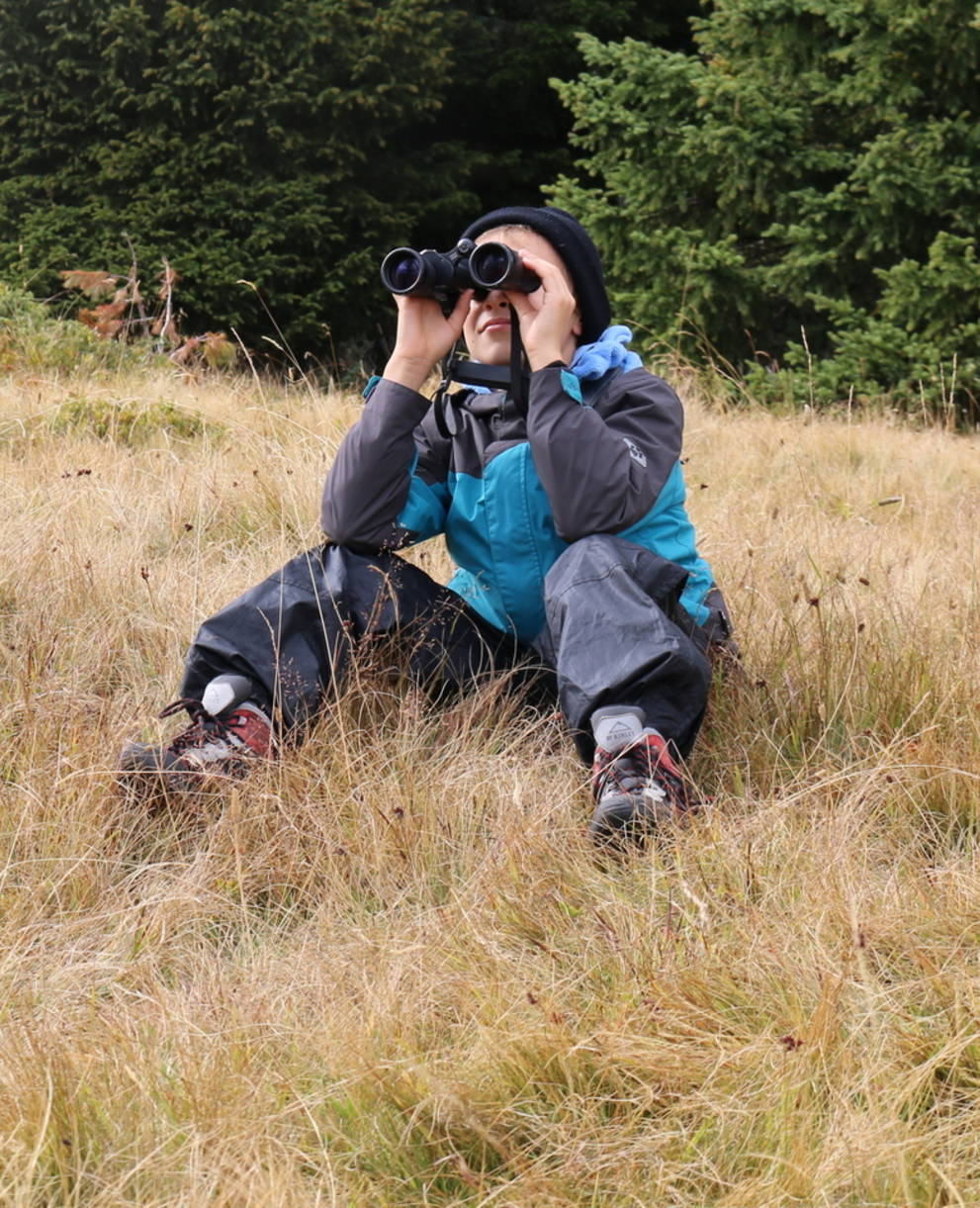 Un enfant observe la nature avec des jumelles