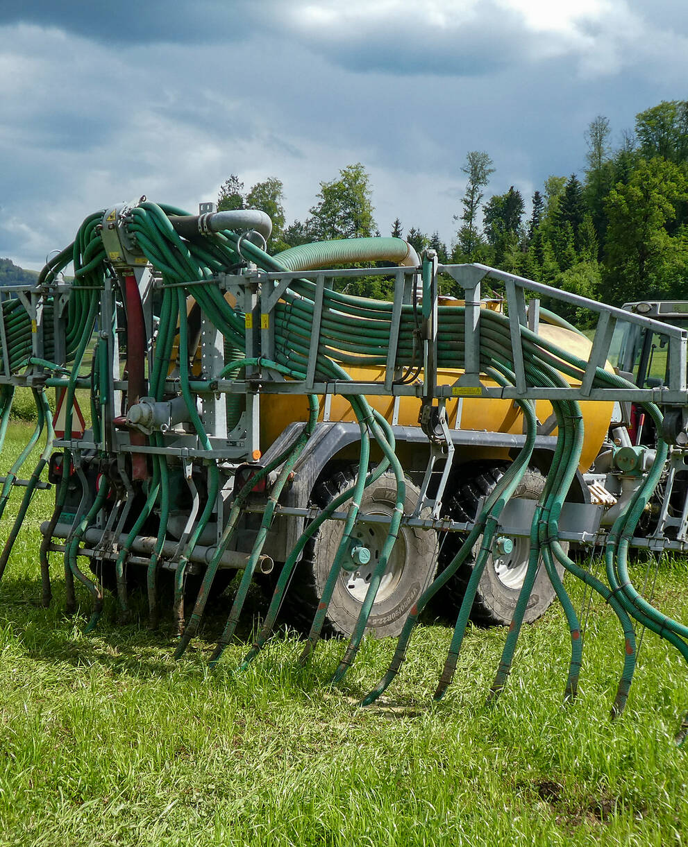Traktor mit Schleppschlauch und Fass auf dem Feld. © Andrea Haslinger